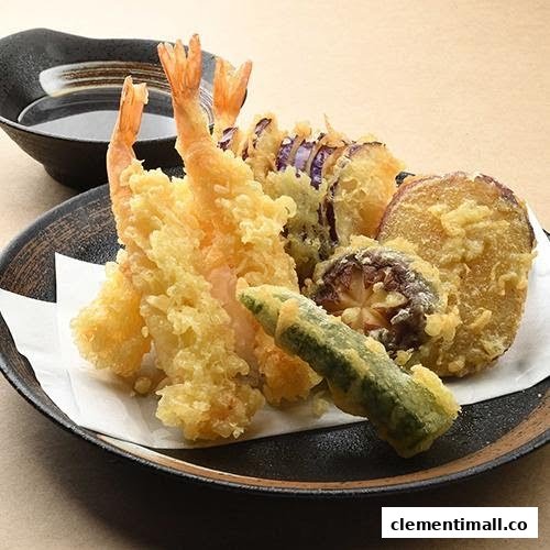 A close-up of a delicious plate of golden-fried tempura, featuring shrimp and assorted vegetables.