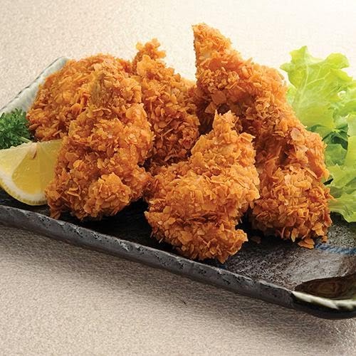 Close-up of golden crispy fried chicken or fish pieces served with a lemon wedge and lettuce.
