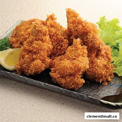 Close-up of golden crispy fried chicken or fish pieces served with a lemon wedge and lettuce.