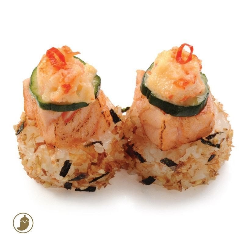 Two pieces of Japanese rice balls topped with grilled salmon, cucumber, and creamy seafood.