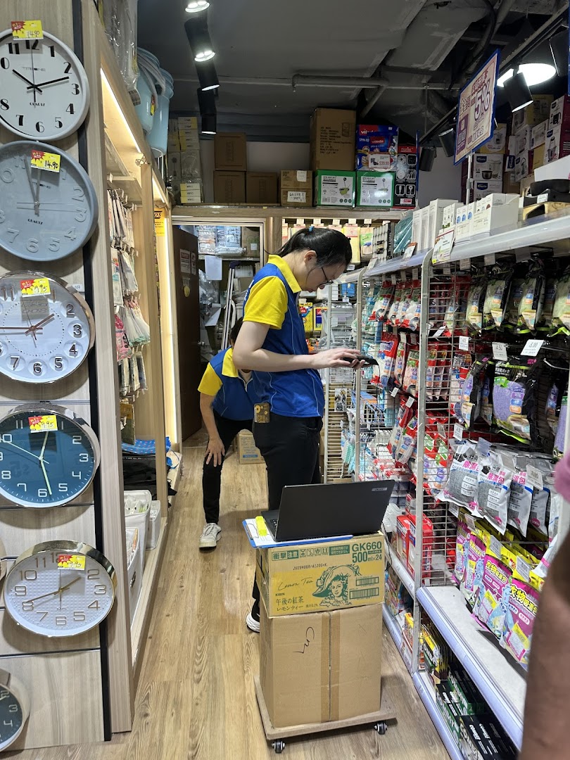 Staff members organize shelves filled with household goods and clocks inside a Japan Home store.