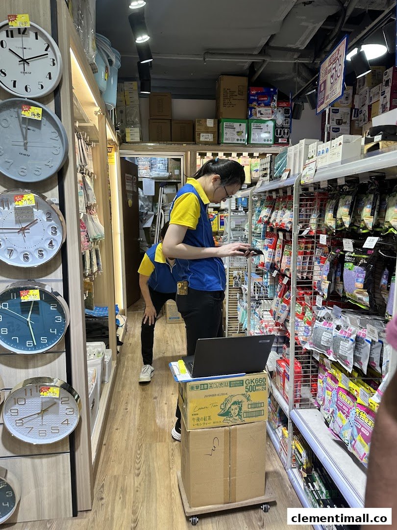 Staff members organize shelves filled with household goods and clocks inside a Japan Home store.