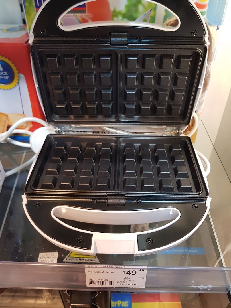 An open white waffle maker with a price tag is displayed in a Japan Home store.