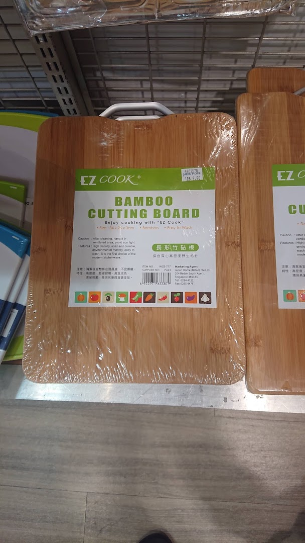 A close-up of an EZ Cook bamboo cutting board with product information and pricing on a shelf.