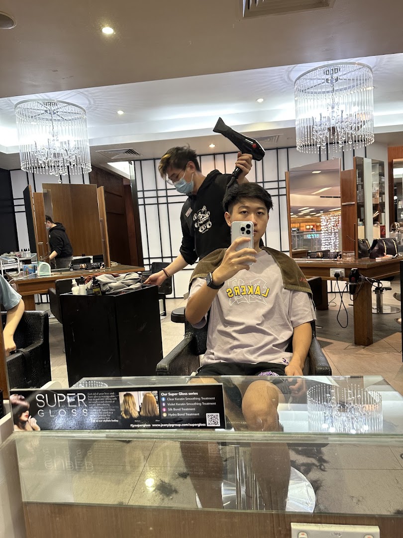 A stylist blow-dries a customer's hair inside Jean Yip Hairdressing, showcasing the salon's modern interior.