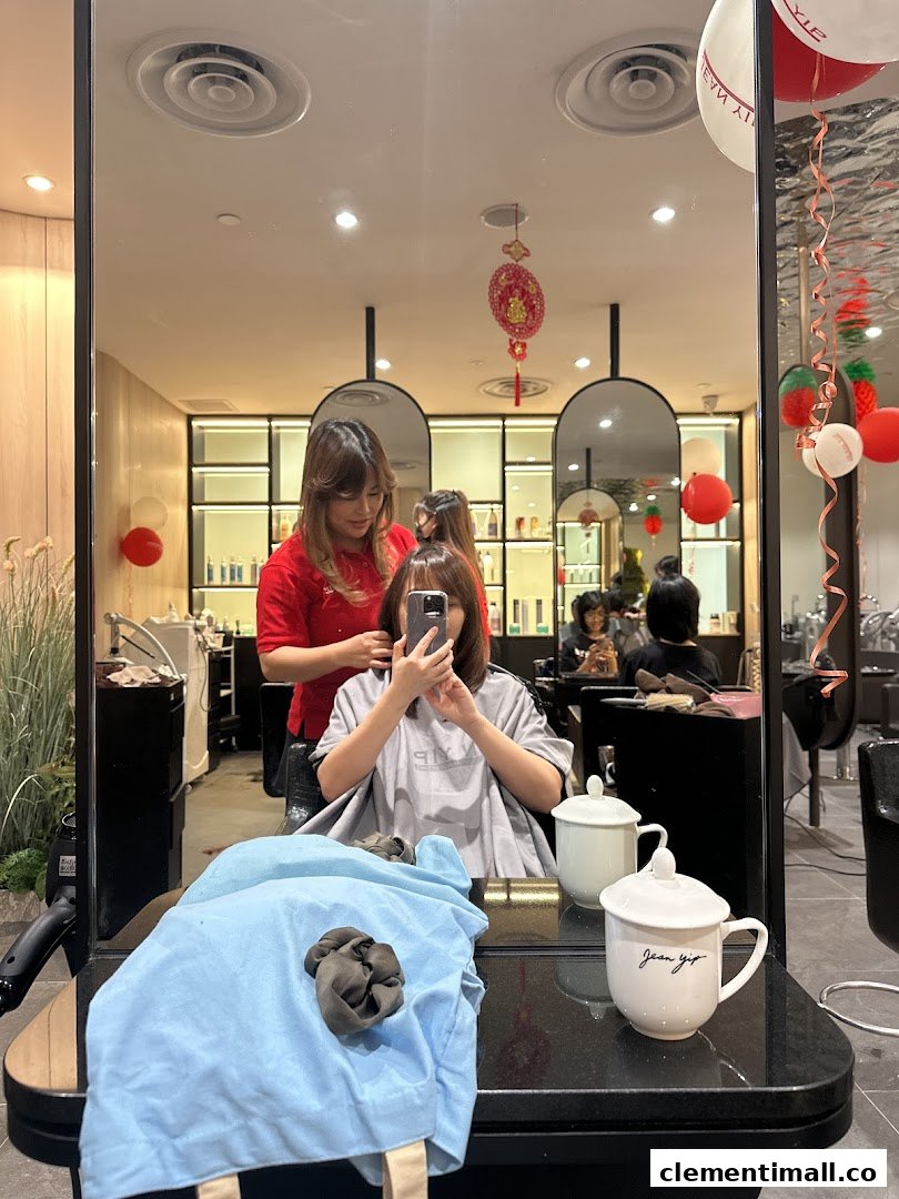 A customer receives a hair service from a stylist inside Jean Yip Hairdressing salon, reflected in a mirror.