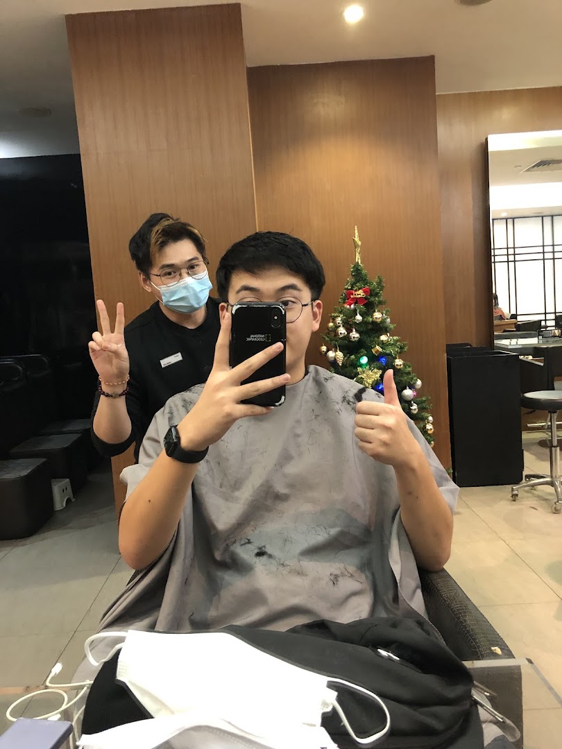 A customer takes a selfie with a stylist in a modern salon, featuring a festive Christmas tree.