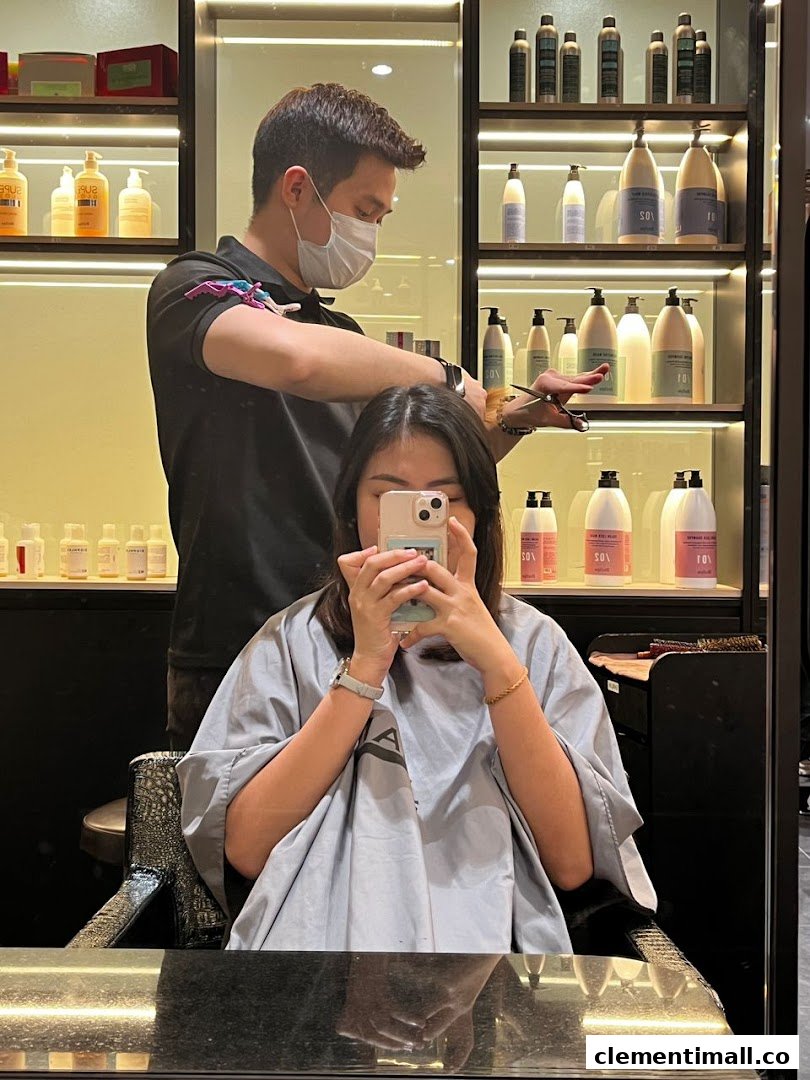 A stylist gives a customer a haircut inside Jean Yip Hairdressing, surrounded by hair products.