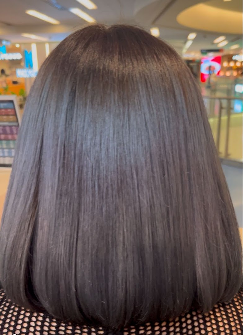 A close-up of a person's smooth, dark hair, likely after a treatment at the salon.