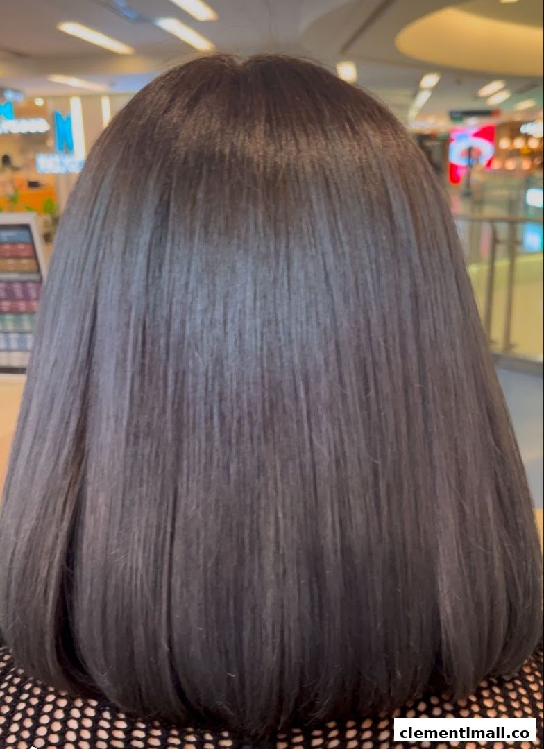 A close-up of a person's smooth, dark hair, likely after a treatment at the salon.