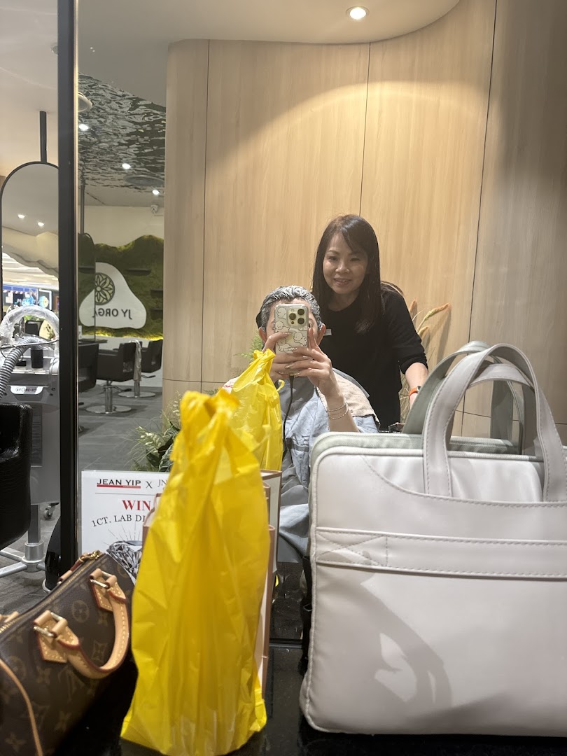 A customer receives a hair treatment from a stylist, reflected in a mirror at Jean Yip Hairdressing.