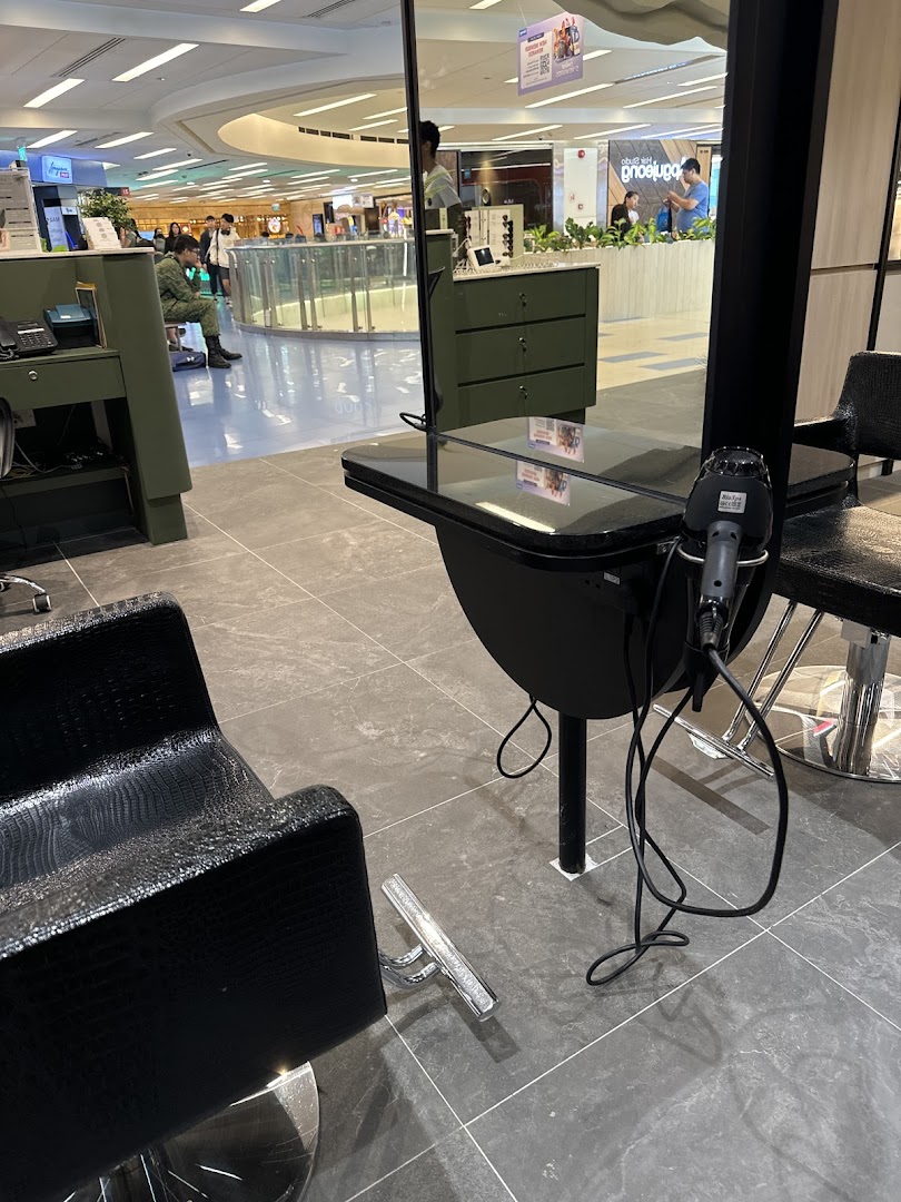 An interior view of Jean Yip Hairdressing, showing a modern styling station with a chair and mirror.