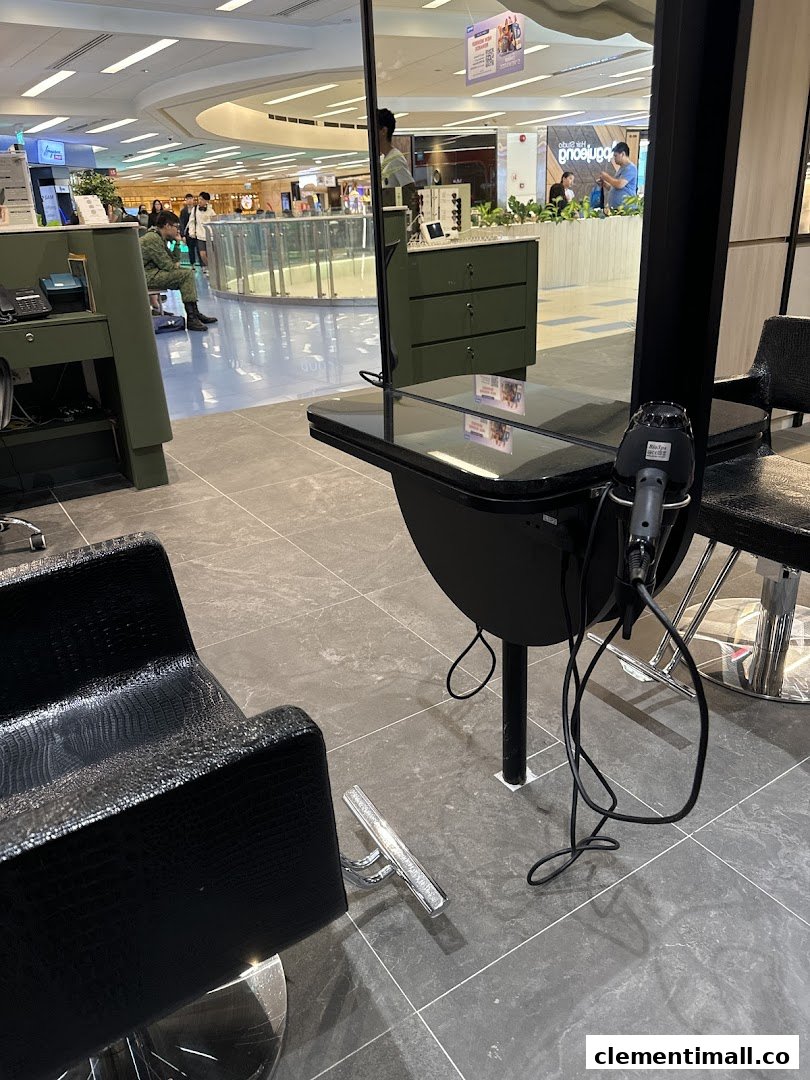 An interior view of Jean Yip Hairdressing, showing a modern styling station with a chair and mirror.