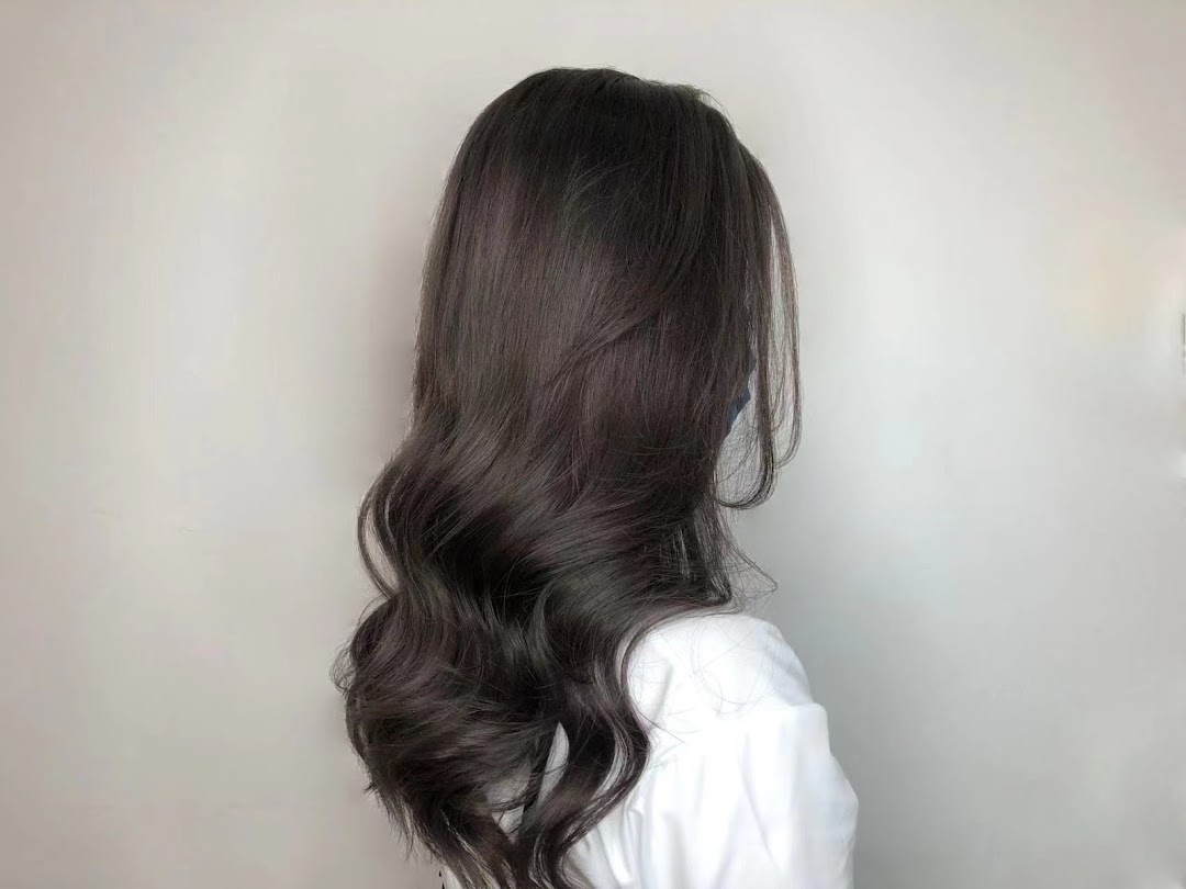 A person showcasing long, dark, wavy hair, likely a result of styling at Jean Yip Hairdressing.