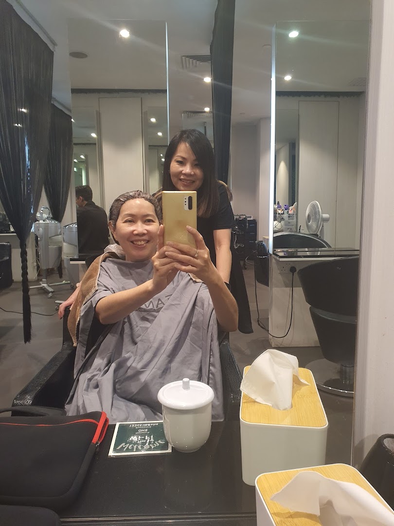 A happy customer takes a selfie with a Jean Yip staff member during a hair treatment.