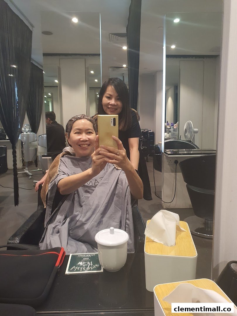 A happy customer takes a selfie with a Jean Yip staff member during a hair treatment.