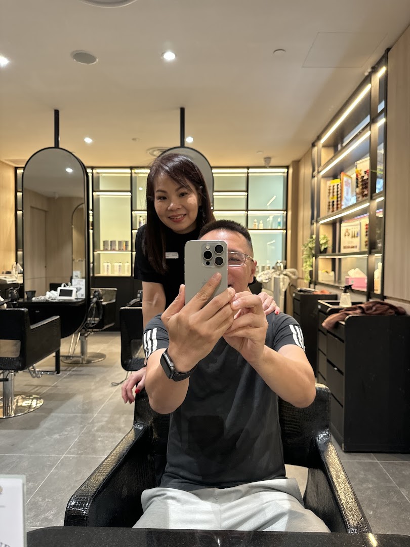 A customer takes a selfie with a friendly staff member inside Jean Yip Hairdressing salon.