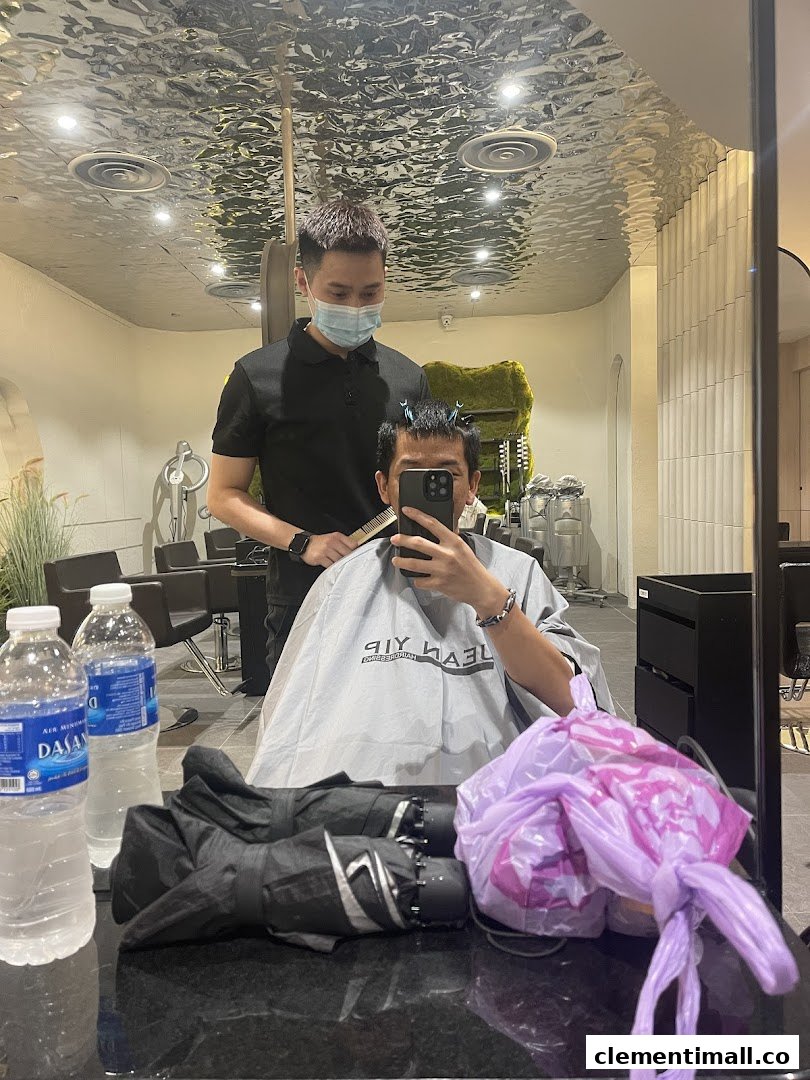 A customer receives a haircut from a stylist inside Jean Yip Hairdressing salon, reflected in a mirror.
