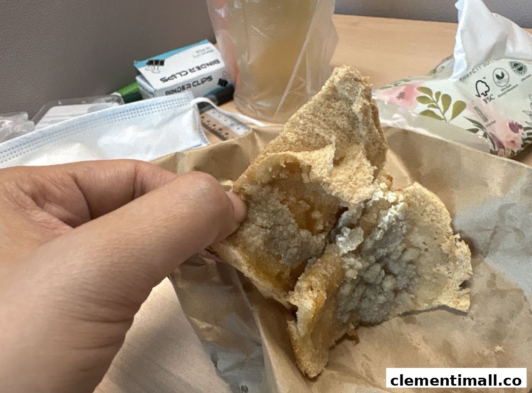 A hand holds a piece of sweet toast from Kaffe Toast Thai Noodle Bar, showing its delicious filling.