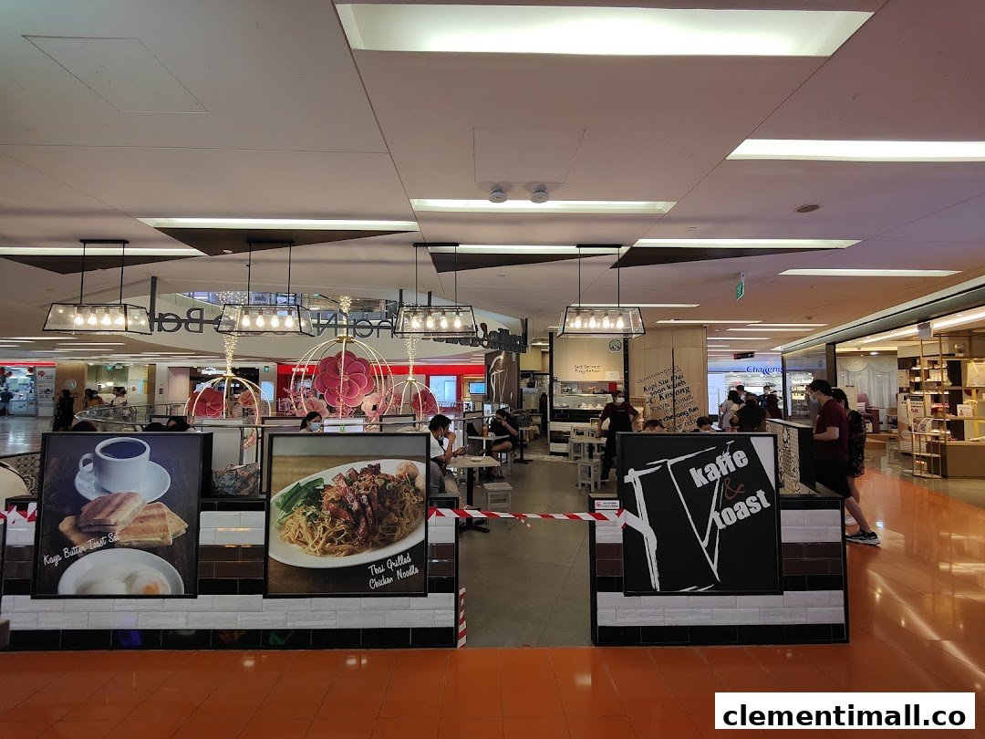 An interior view of Kaffe Toast Thai Noodle Bar, showcasing diners and promotional food displays.