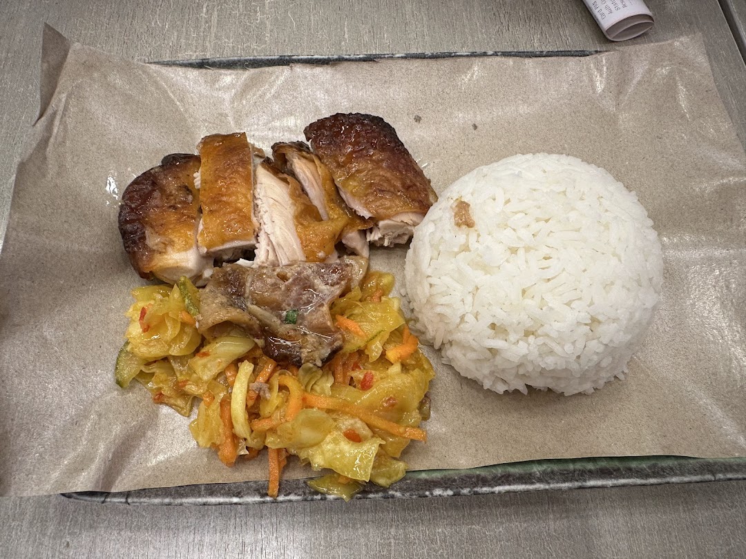 A delicious plate featuring roasted chicken, fluffy rice, and a vibrant side dish.