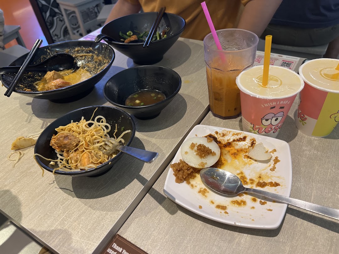 A table with finished noodle bowls, a dessert plate, and drinks at Kaffe Toast Thai Noodle Bar.