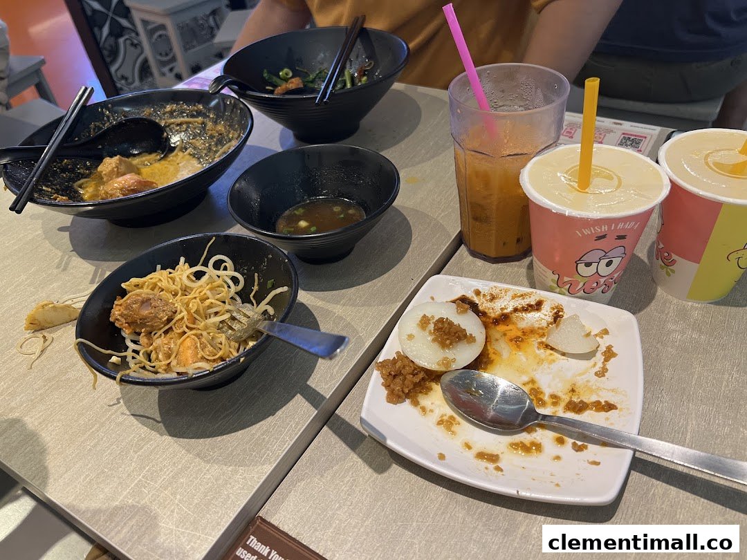 A table with finished noodle bowls, a dessert plate, and drinks at Kaffe Toast Thai Noodle Bar.