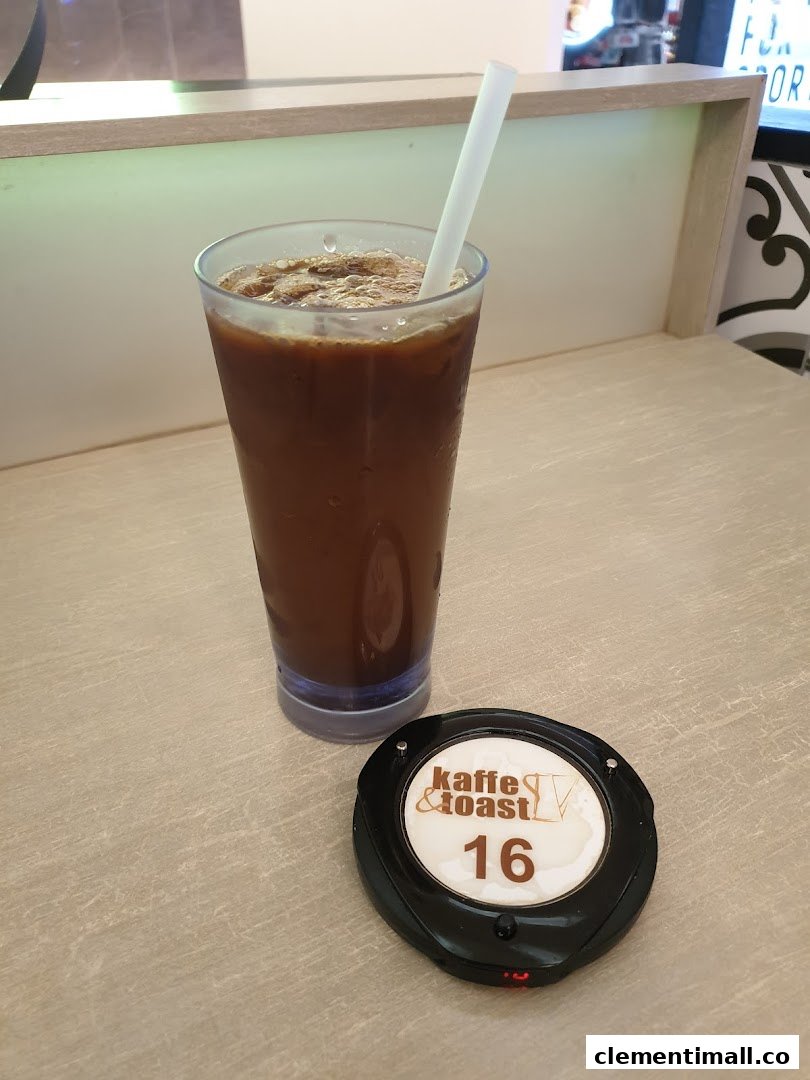 An iced coffee drink and a Kaffe & Toast pager on a light-colored table.