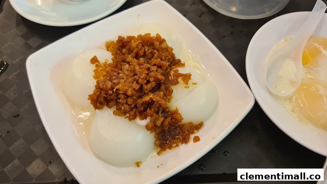 A close-up of traditional Asian breakfast items, including white rice cakes with savory topping and soft-boiled eggs.