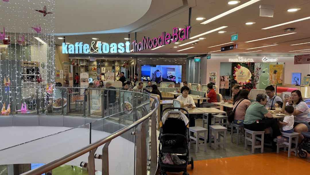 A bustling view of Kaffe & Toast Thai Noodle Bar within a shopping mall, with customers dining.