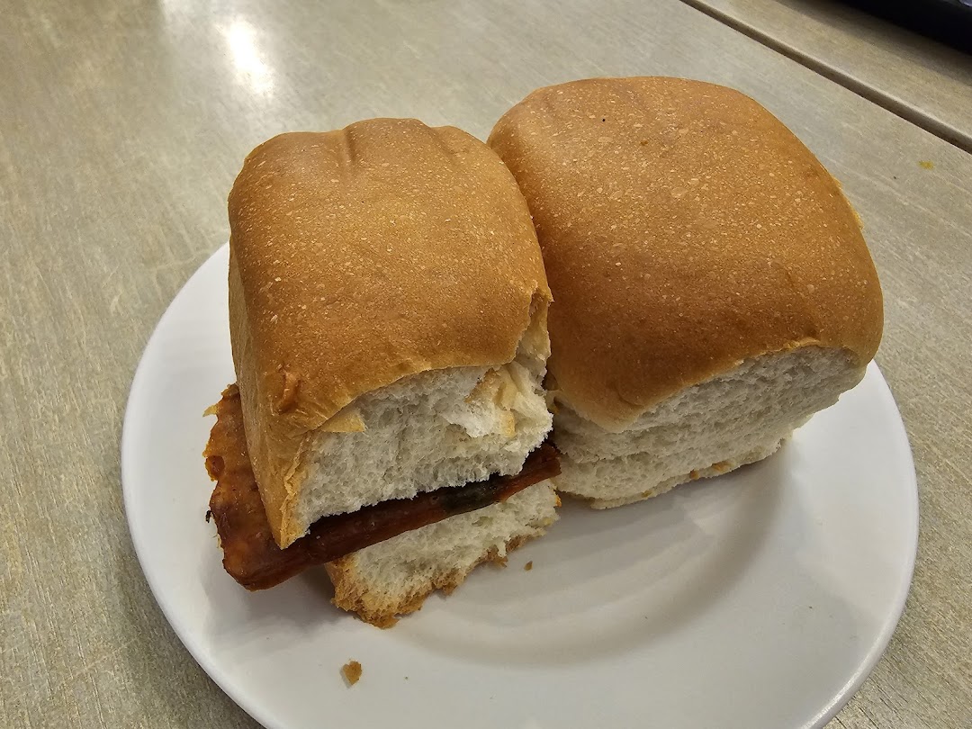 Two golden-brown buns with a savory filling served on a white plate.