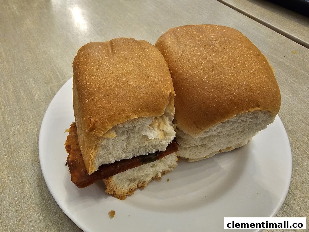 Two golden-brown buns with a savory filling served on a white plate.