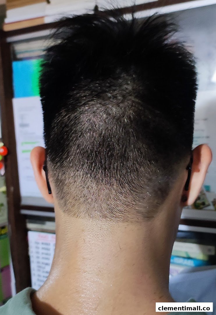 Close-up of a fresh haircut with a clean fade at the back of a customer's head.