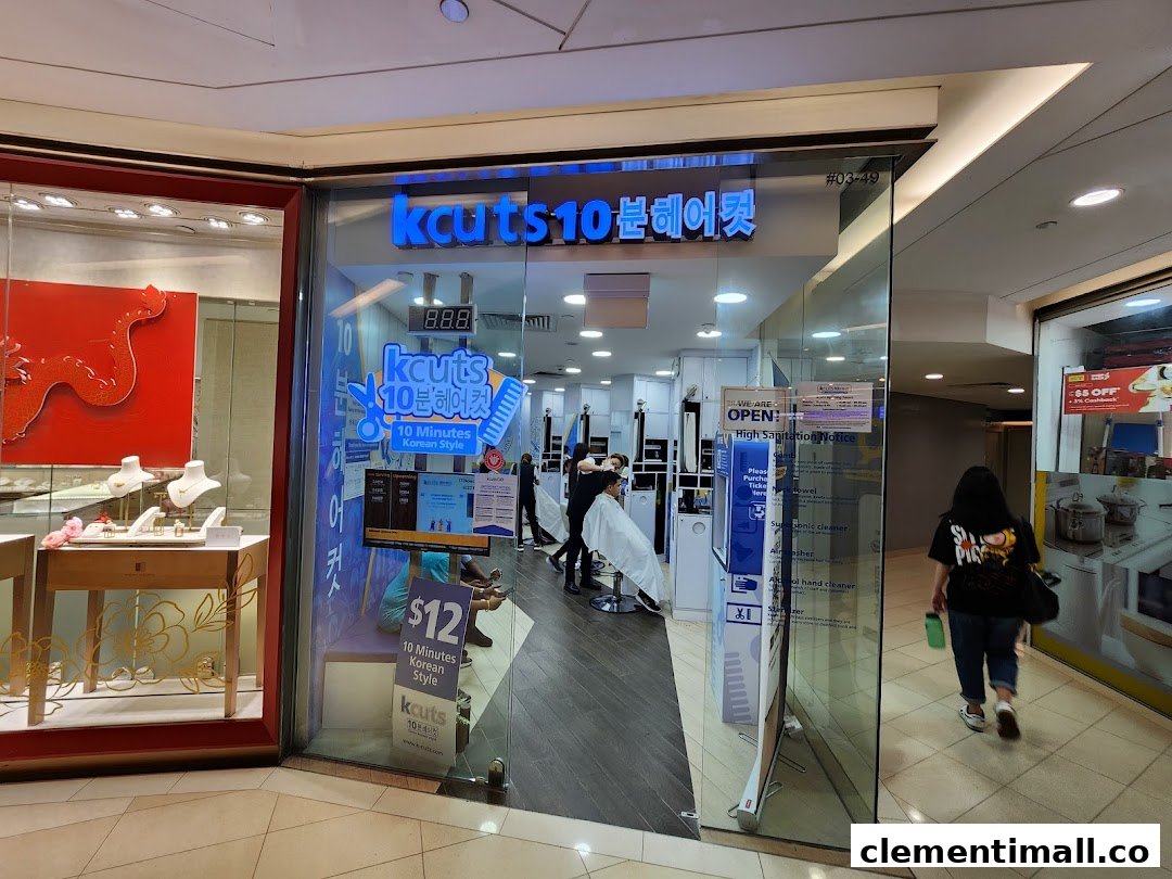 The glass storefront of kcuts hair salon, showcasing its interior with customers and promotional signage.