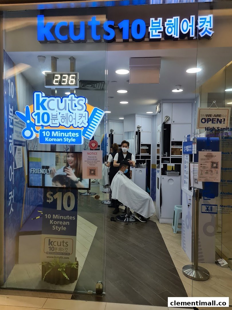 The storefront of kcuts, a hair salon, showing a customer receiving a haircut inside.
