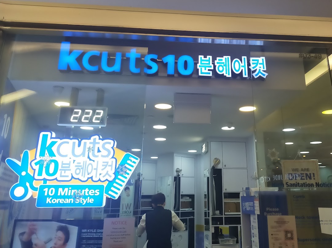 The shopfront of kcuts, a hair salon, featuring its logo, a queue number display, and promotional decals.