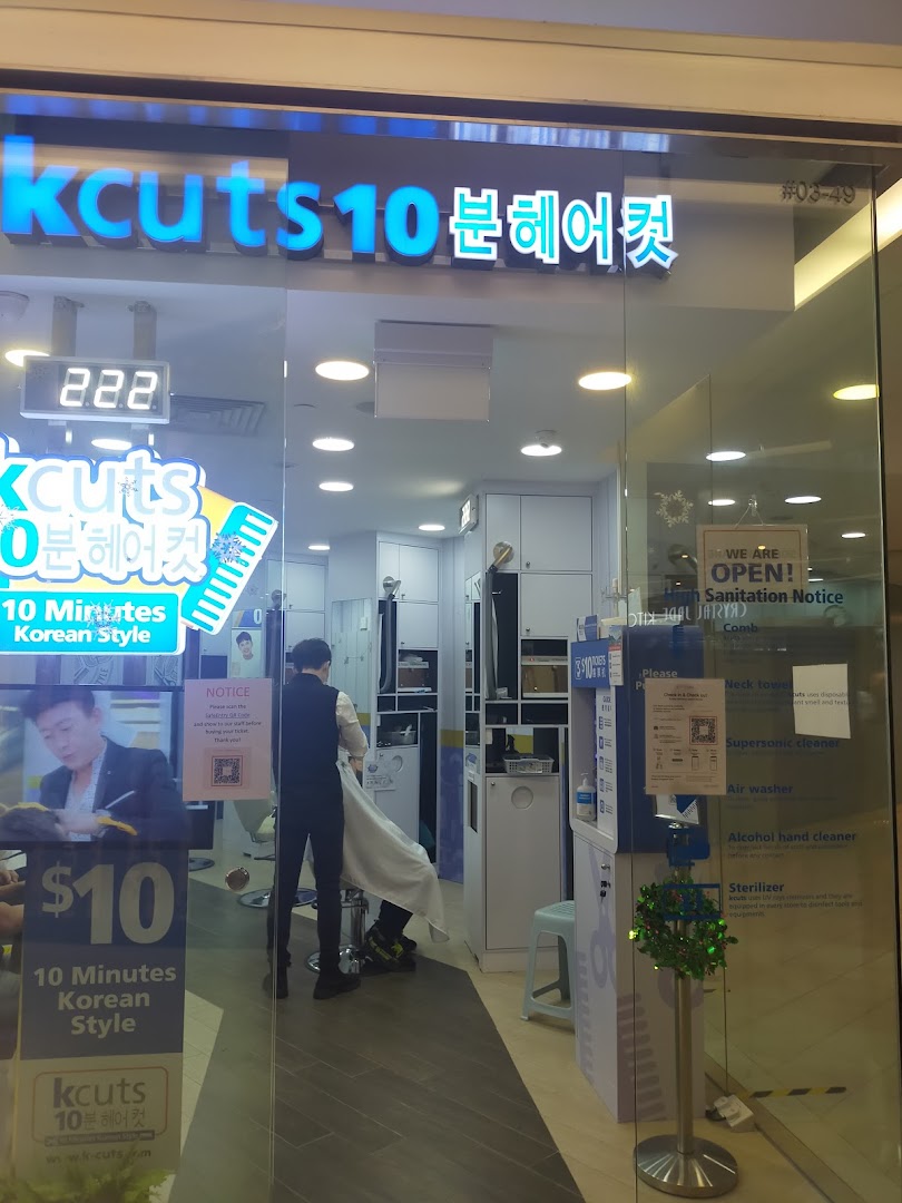 The storefront of kcuts, a hair salon offering 10-minute Korean style haircuts, with a customer inside.