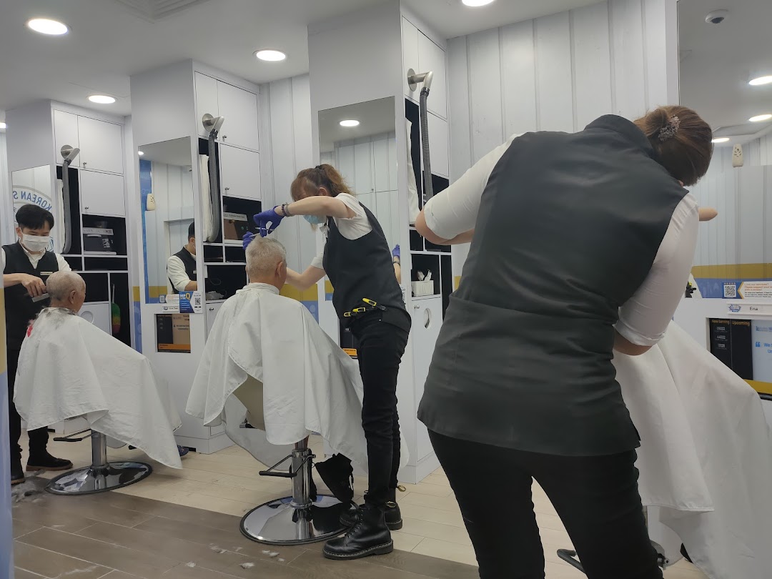 Inside kcuts Clementi Mall, stylists provide quick haircuts to customers in a clean, modern setting.