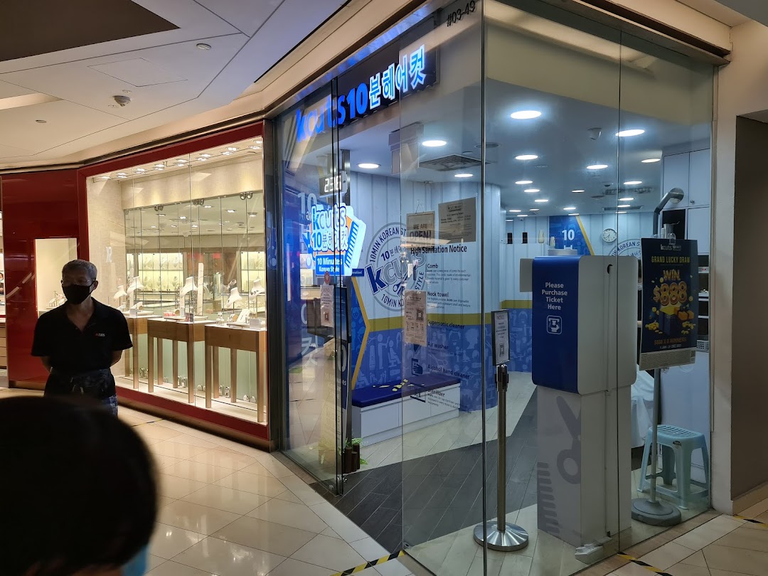 The storefront of kcuts, a Korean-style haircut salon, featuring its entrance and interior view.