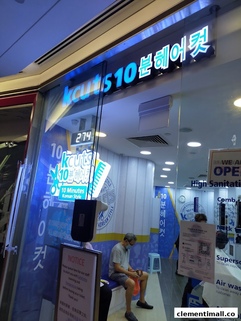 The brightly lit storefront of kcuts, a Korean-style express haircut salon, with a customer waiting inside.