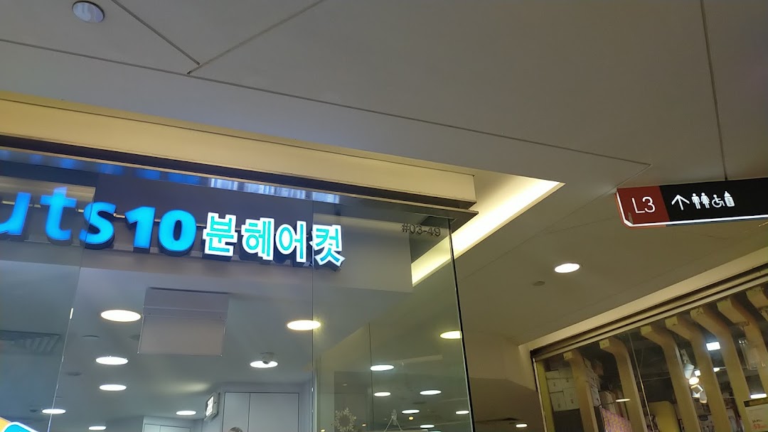 Partial view of kcuts shop front with blue illuminated signage and mall directory sign.