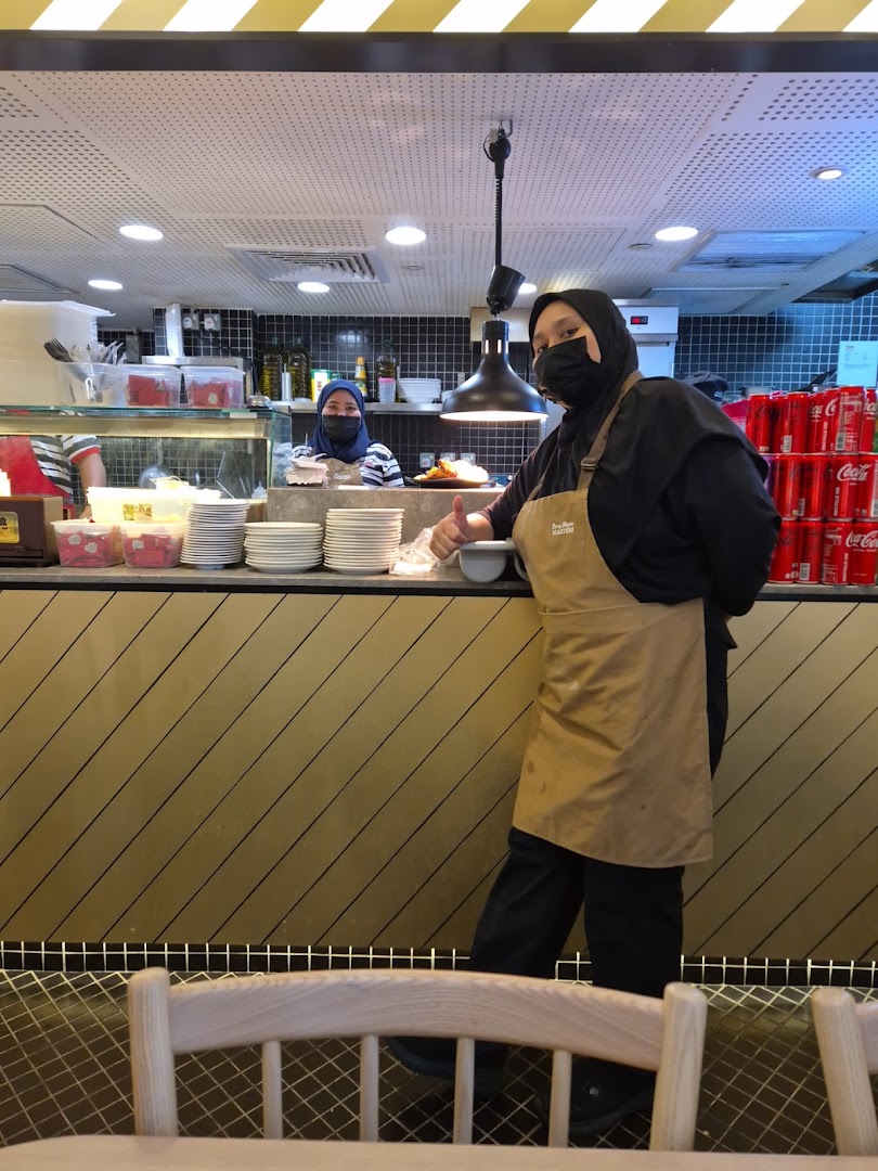 Friendly staff at Kenny Rogers Roasters Express counter, ready to serve with a thumbs-up.
