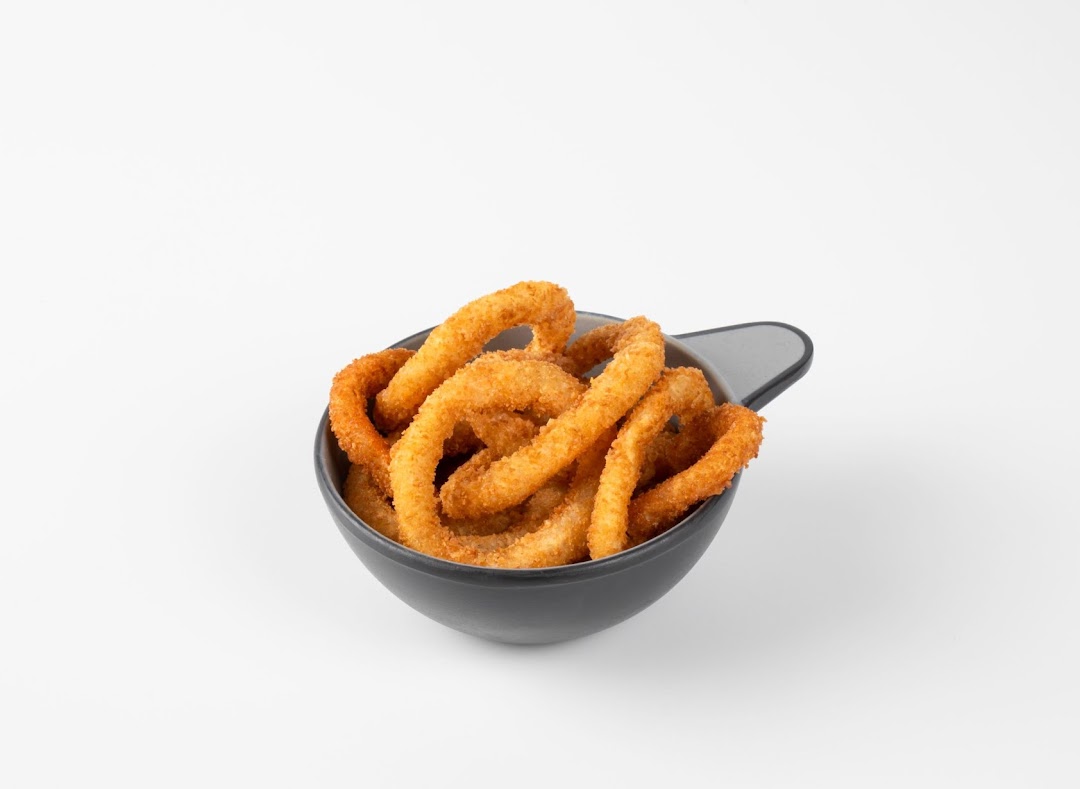 A bowl of golden-brown, crispy onion rings on a plain white background.