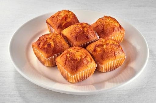 A white plate holds six golden-brown muffins, a signature side from Kenny Rogers Roasters.