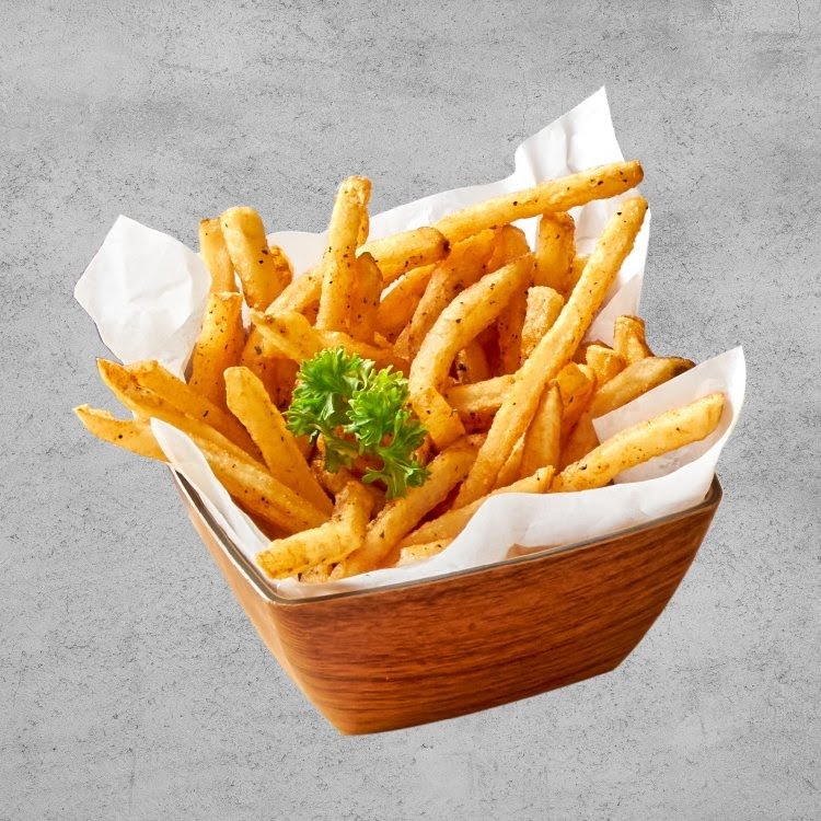 A wooden bowl filled with golden, seasoned french fries, garnished with fresh parsley.