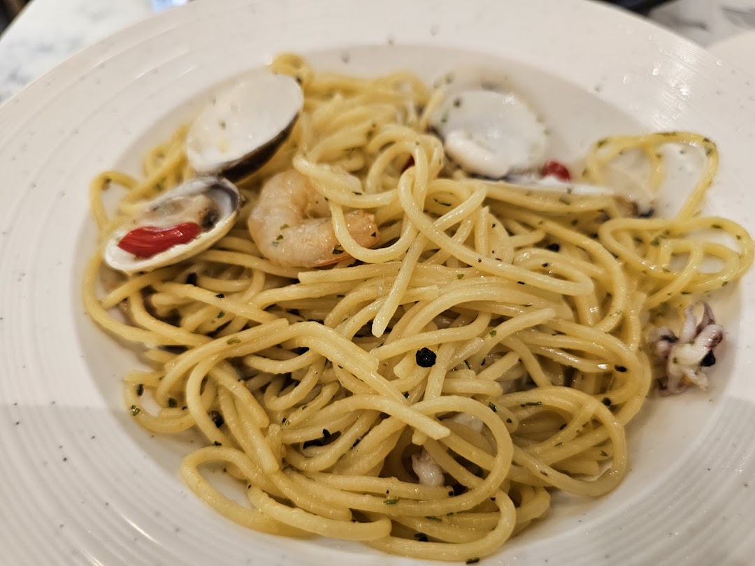 A close-up of a delicious seafood spaghetti dish with clams, shrimp, and squid.