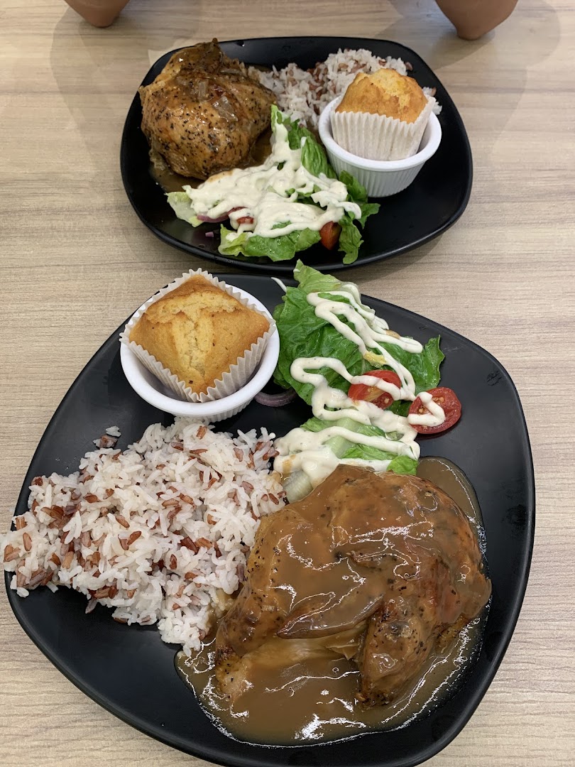 Two plates of Kenny Rogers Roasters' signature roasted chicken meals with rice, salad, and muffin.