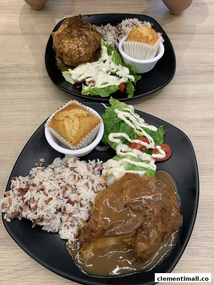 Two plates of Kenny Rogers Roasters' signature roasted chicken meals with rice, salad, and muffin.