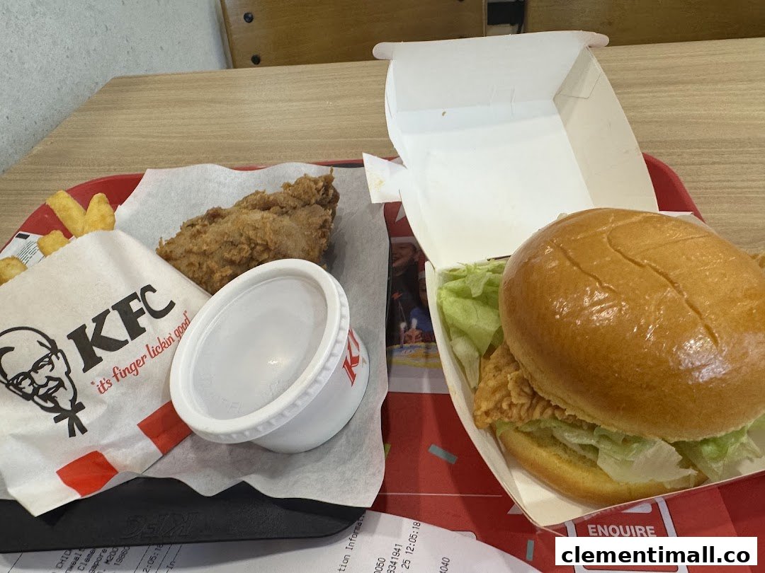 A delicious KFC meal featuring fried chicken, a burger, fries, and sauce on a red tray.