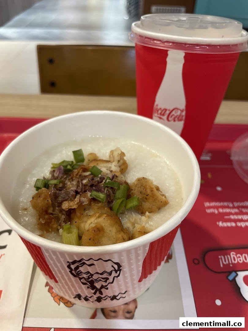 A close-up of KFC's chicken porridge and a Coca-Cola drink on a red tray.